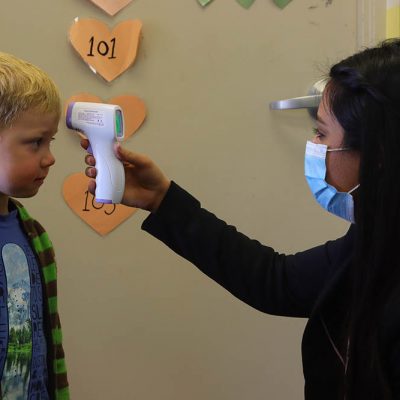 A young child arriving at the Clever Day Care Centre in Calgary gets his tempearture taken with this portal scanning gun. All children are scanned in the morning before heading to class to keep the facility Covid-19 free.
