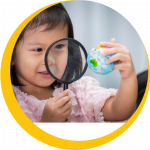 Picture of toddler with magnifier and a globe